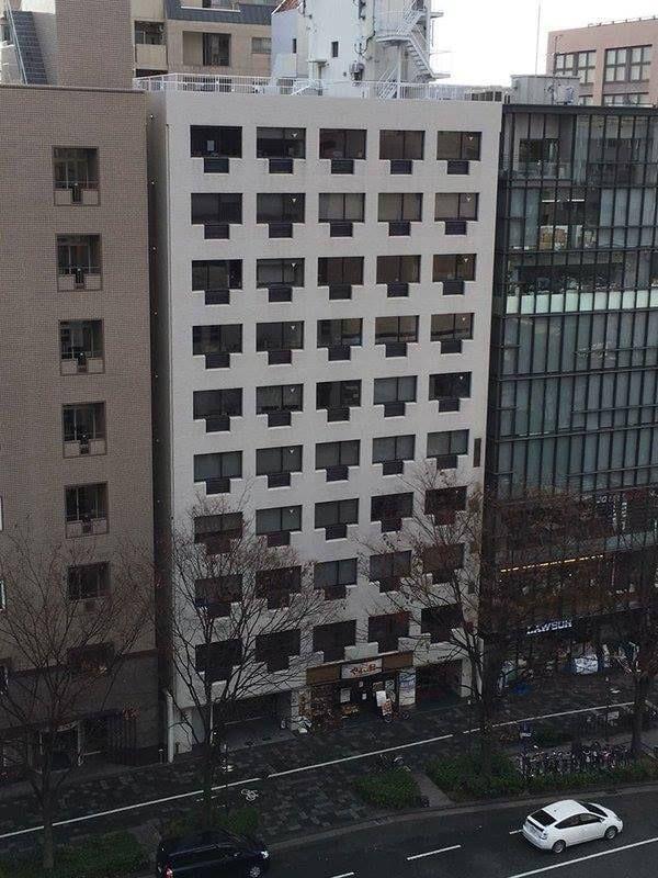 A nine story building with Windows and Coolers that look exactly like ethernet ports.
